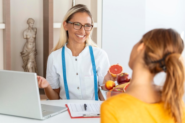 Nutricionista feminina dando consulta ao paciente fazendo plano de dieta