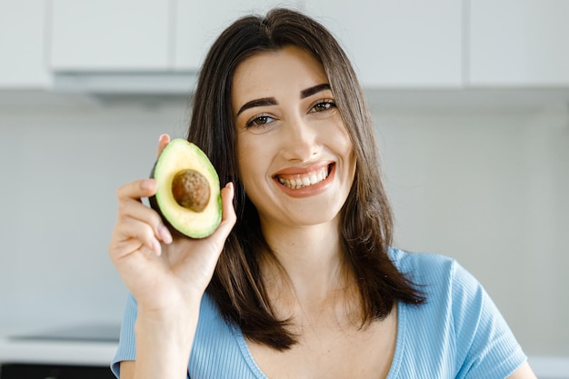 Nutricionista feminina mostra legumes frescos de abacate e uma fita métrica em sua mesa conceito de saúde