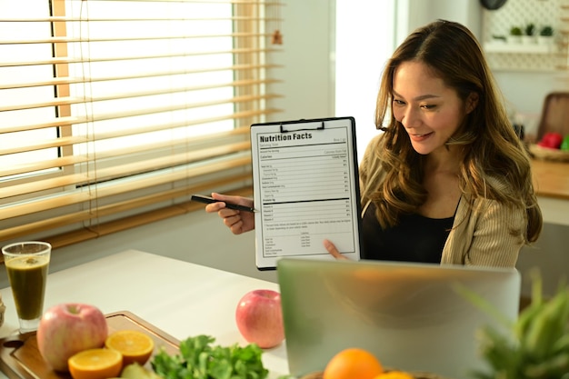 Nutricionista feminina mostrando exemplo de menu semanal de paciente durante consultas on-line via laptop Nutrição correta alimentação saudável