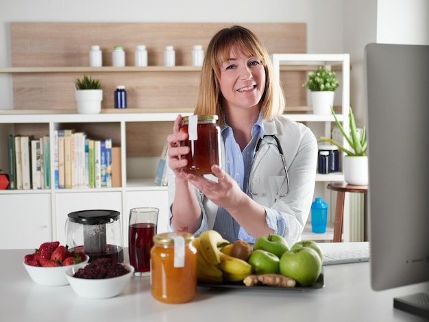 Foto nutricionista feminina segurando mel no estúdio de escritório