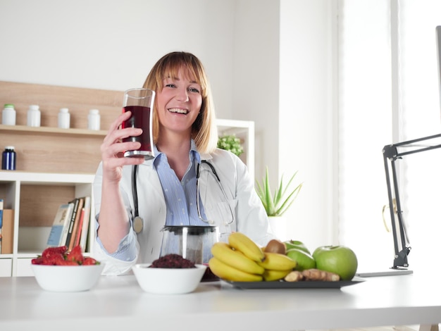 Nutricionista feminina segurando um copo de bebida de infusão de hibisco