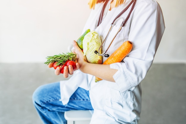 Nutricionista médica holbing alimentos saudáveis nas mãos.