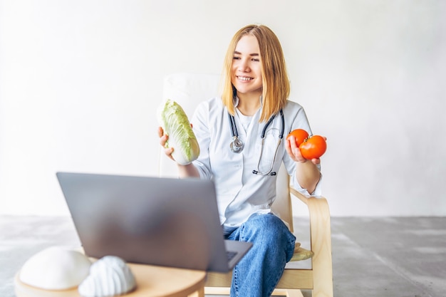 Nutricionista médica realiza consulta online com laptop.