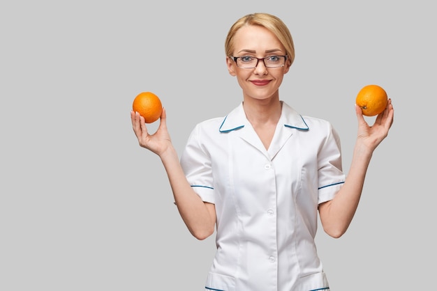 nutricionista médico conceito de estilo de vida saudável - segurando frutas frescas de laranja orgânica
