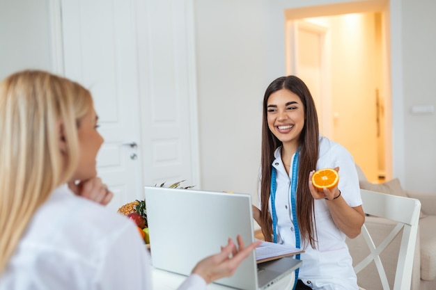 Nutricionista profissional encontrando um paciente no escritório e frutas saudáveis com fita métrica