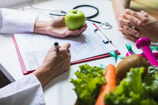 Foto nutricionista que consulta al paciente con frutas y verduras saludables, nutrición y dieta adecuadas