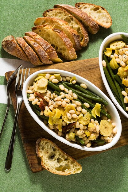 Nutritiva salada de feijão branco cannellini com feijão verde, tomate seco e alcachofra em óleo.