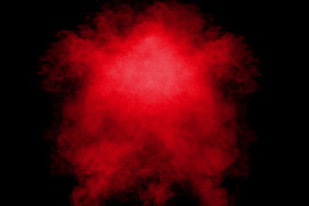 Nuvem alaranjada vermelha da explosão do pó da cor no fundo preto.