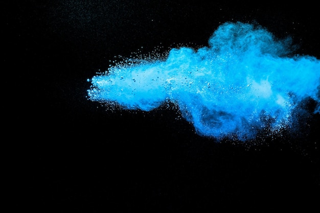 Nuvem de explosão de pó azul sobre fundo preto Salpicos de partículas de poeira azul lançadas