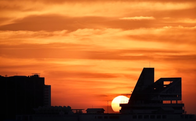 Nuvem fascinante na hora do pôr do sol com silhueta de construção em primeiro plano