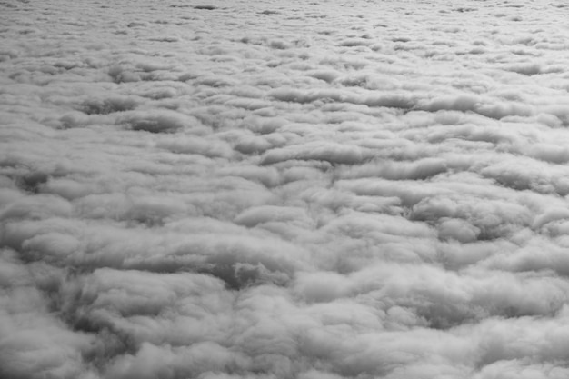 Nuvens altas no céu, nuvens fofas brancas e cinzas da vista da janela do avião