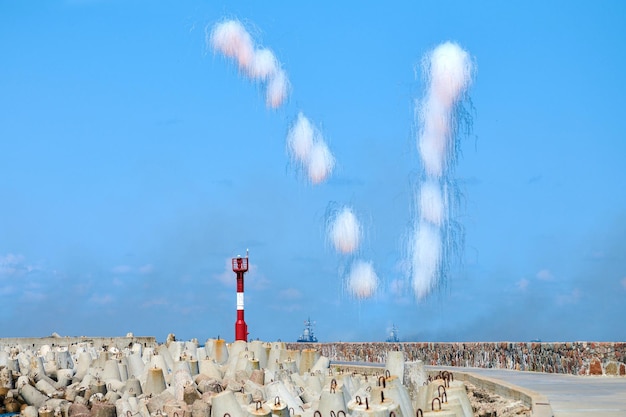 Nuvens brancas de fibra de carbono escondendo destruidores navais de mísseis anti-navio. lançamento de antimísseis em tempo de show militar, fundo de céu azul. navios de guerra em treinamento de combate, bombeiros no mar báltico