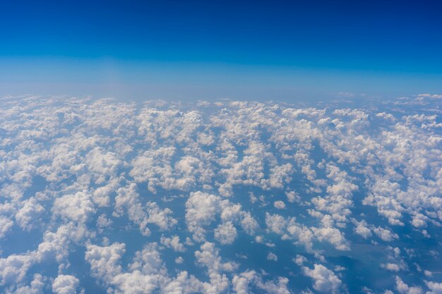 Nuvens brancas e céu azul, uma vista da janela do avião. Fundo da natureza