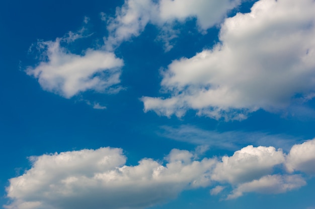 Nuvens cinzas e brancas no céu azul.