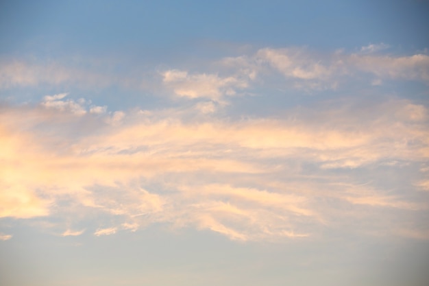 Nuvens Cirrus brancas e rosa em um céu azul em uma noite de verão