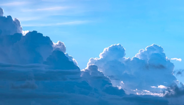 Nuvens cumulonimbus e cumulus claras e escuras dramáticas no fundo do céu azul à noite