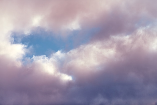 Nuvens cúmulos fofas em uma bela cor roxa e rosa, céu azul nublado