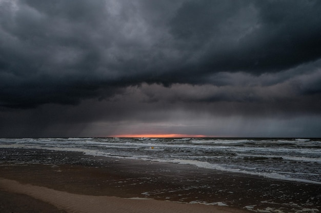 Nuvens de tempestade escuras dramáticas sobre o oceano após o pôr do sol