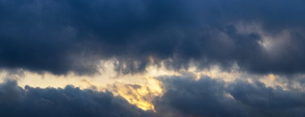 Nuvens de tempestade escuras iluminadas pelo panorama brilhante do sol noturno