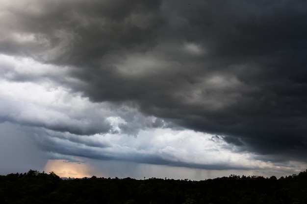 Nuvens de tempestade escuras sobre o prado com grama verde