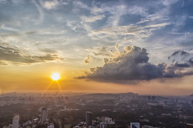 Nuvens do sol sobre o centro da cidade de Kuala Lumpur