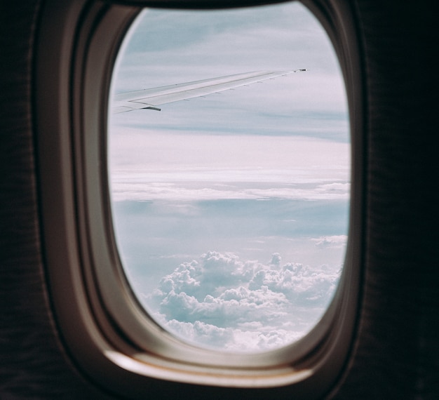 Nuvens e céu pela janela de uma aeronave.