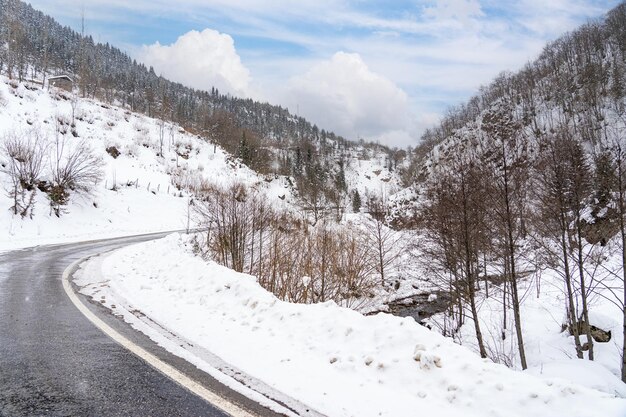 Nuvens e paisagem de estrada sinuosa de dia de inverno nevado