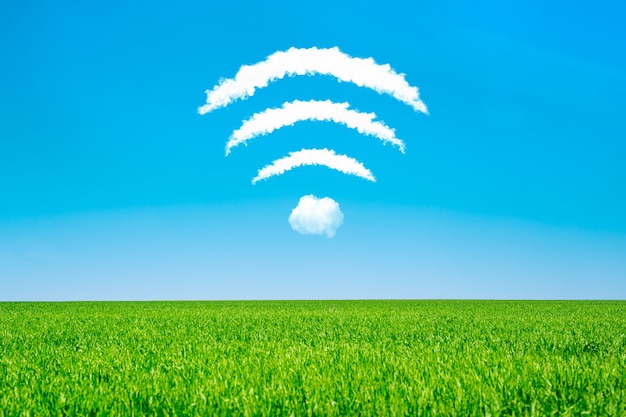 Nuvens em forma de símbolo de wifi em um céu azul e um prado verde