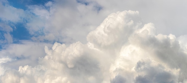 Nuvens encaracoladas brancas no céu azul são iluminadas pelo sol brilhante