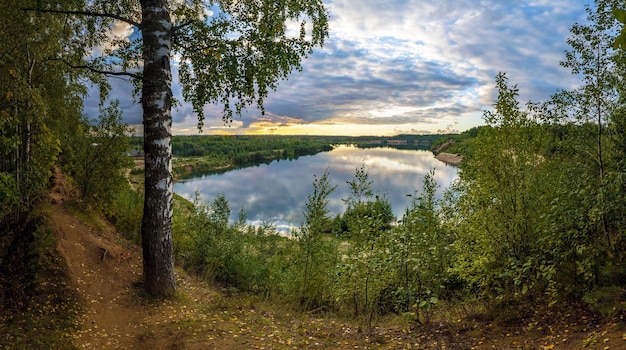 Foto nuvens estão se reunindo sobre o lago à noite antes do pôr do sol