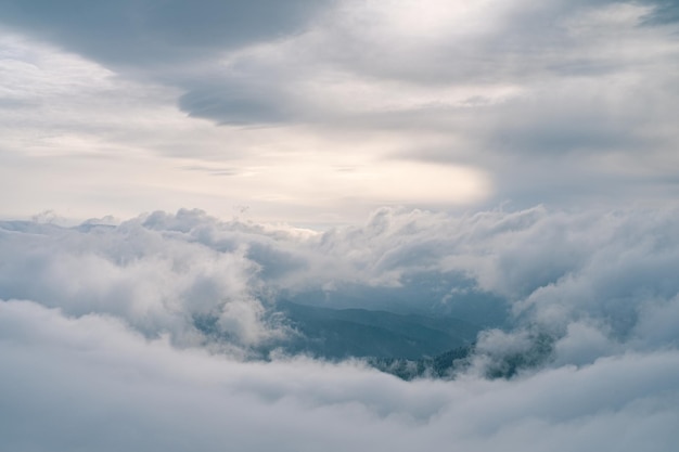 Foto nuvens fluindo na montanha de inverno ao pôr do sol