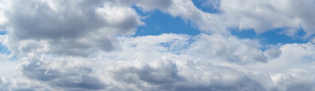 Nuvens fofas brancas em um céu azul, panorama do céu.