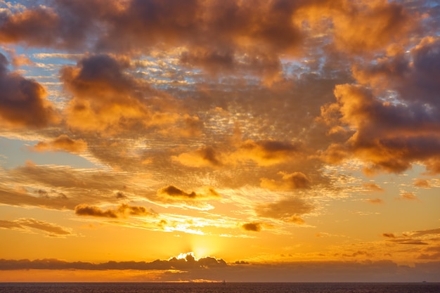 Nuvens laranja no céu acima do Oceano Atlântico ao pôr do sol - Vista do mar