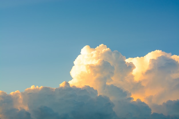 Nuvens macias brancas no céu azul claro em um por do sol alaranjado brilhante