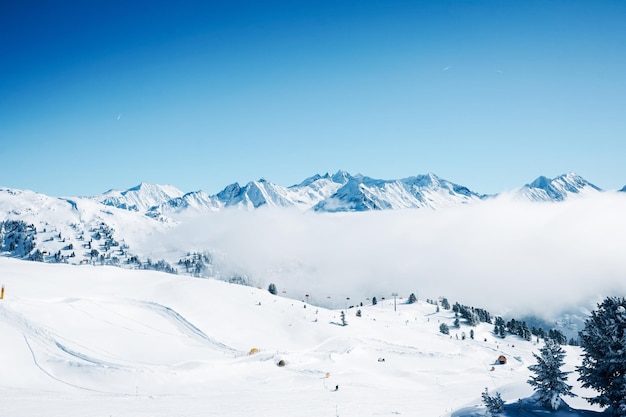 Nuvens na estância de esqui Zillertal Arena em Zillertal no Tirol. Mayrhofen na Áustria no inverno nos Alpes. Montanhas alpinas com neve. Diversão em declive. Céu azul e encostas brancas em Zell am Ziller.