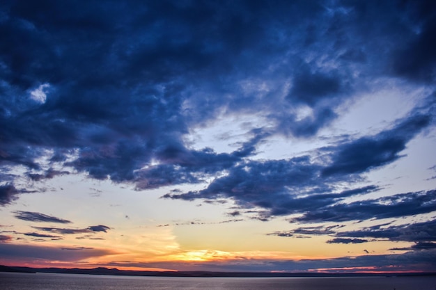 Nuvens no céu azul durante o pôr do sol sobre o mar