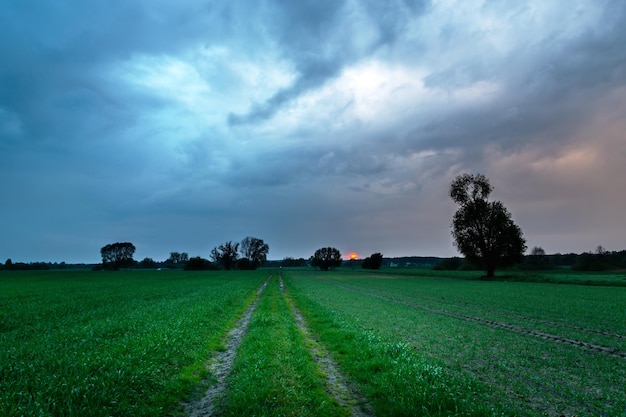 Foto nuvens noturnas incríveis sobre o campo com a estrada