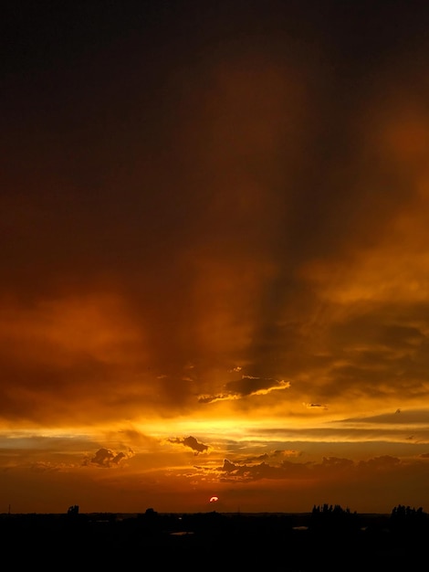 Nuvens pesadas da paisagem azul e dourada incrível do por do sol