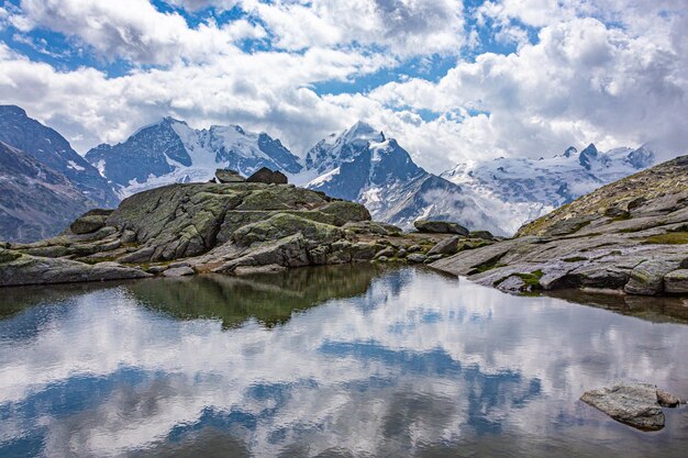 Nuvens refletidas na água contra as montanhas