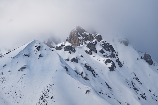 Foto nuvens sobre o topo de uma montanha de neve nos alpes austríacos