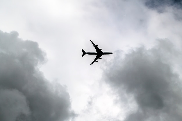 Nuvens tempestuosas no céu escuro e um avião de passageiros. aviões a jato no fundo do céu dramático. moody cloudscape.