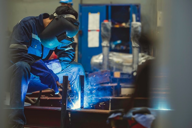 O aço de metal do trabalhador masculino de soldagem é parte da estrutura do feixe