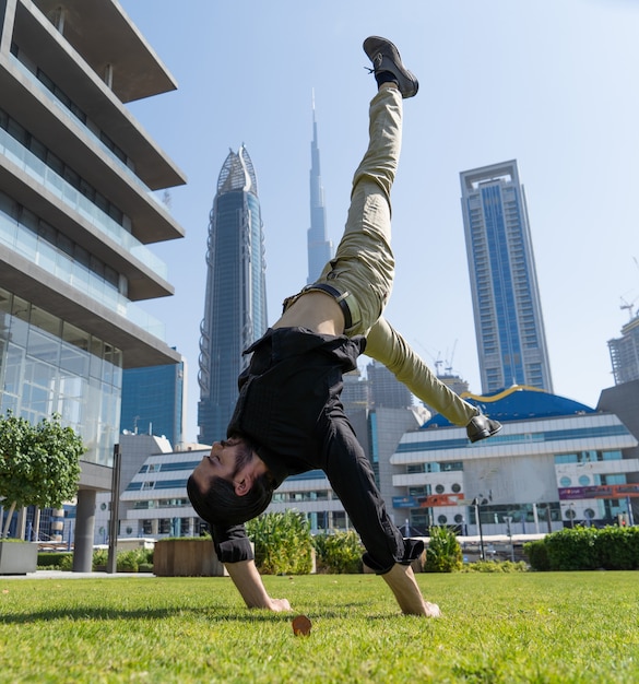 O acrobat mantém o equilíbrio entre as mãos com a paisagem urbana borrada de dubai. conceito de modernidade, negócios e possibilidades ilimitadas.