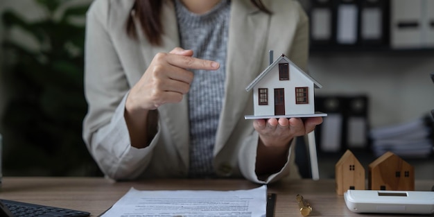 O agente imobiliário falou sobre os termos do contrato de compra de casa e pediu ao cliente que assinasse os documentos para tornar o contrato legalmente Vendas de casas e conceito de seguro residencial