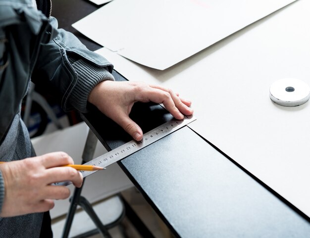 O alfaiate do desenhista costura as tampas de assento. homem usar a máquina de costura para o seu trabalho.