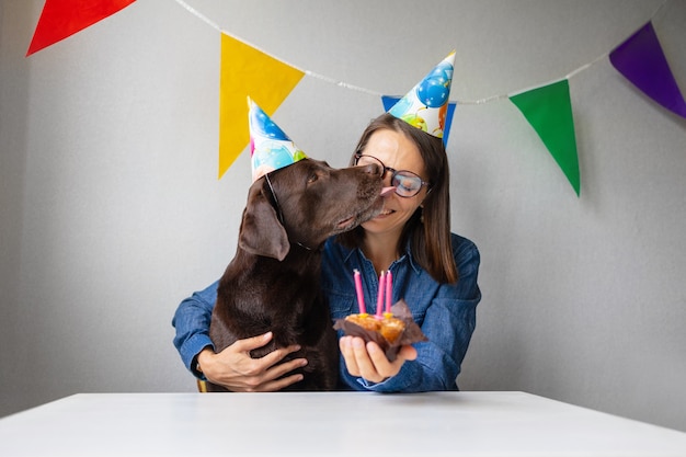 Foto o aniversário dos cães o feriado é o aniversário de velas de um animal de estimação e um bolo para um labrador retriever