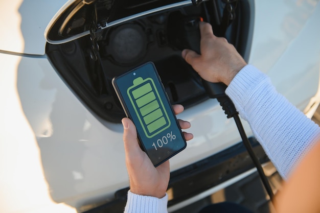 O aplicativo para smartphone mostra o status de carregamento da bateria do carro elétrico. Conceito de transporte elétrico