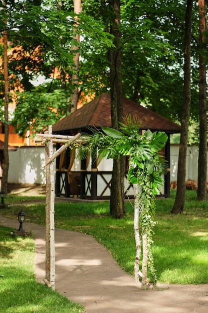 Foto o arco de casamento decorado com folhas verdes ao ar livre cerimônia de casamento