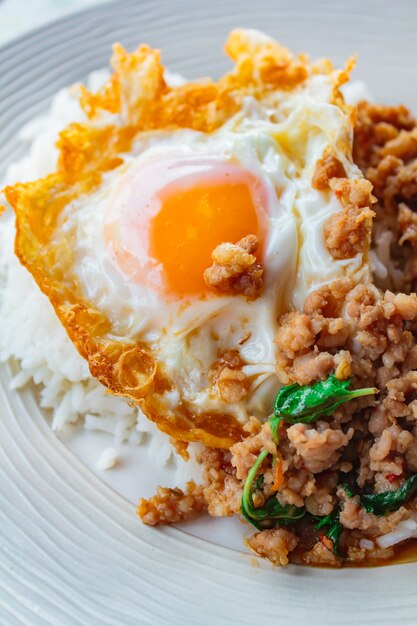 O arroz coberto com carne de porco salteado e manjericão serviu com ovo frito.