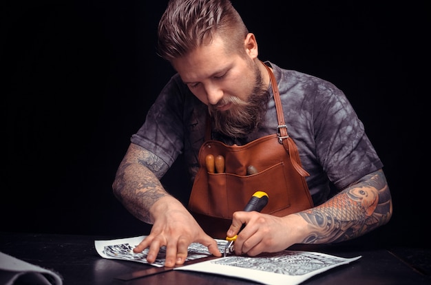 Foto o artesão do couro produz um bom produto no local de trabalho.